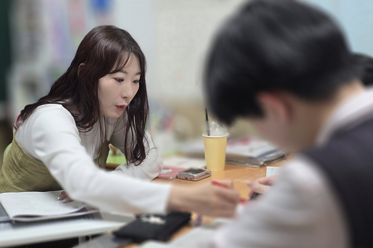백마 소수정예 수학학원 킬영어수학전문학원에서 선생님이 학생 옆에서 수학을 개인별로 지도하는 한 반 여섯 명 소수정예 수업 모습